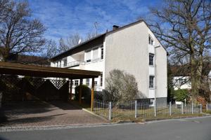a white building with a fence in front of it at Apartment Aurachtal Oberreichenbach in Oberreichenbach