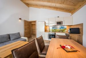cocina y comedor con mesa de madera en Stockis Mountaindestillerie - Appartements en Leogang