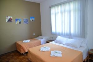 twee bedden in een hotelkamer met handdoeken erop bij Pousada Segredo in São João del Rei
