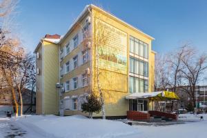 un edificio giallo con la neve davanti di Apartment House a Buzuluk
