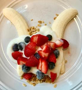 a bowl of a fruit salad with strawberries and blueberries at Goldilocks Bed & Breakfast in Kodiak