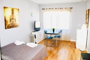 a bedroom with a bed and a desk and a television at Resitur Luxury Apartment 532 in Seville