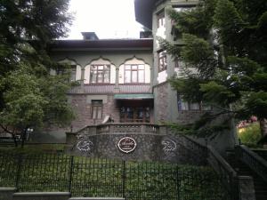 an old house with a fence in front of it at Vila Acvila in Sinaia