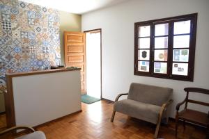 een woonkamer met een stoel en een raam bij Pousada Segredo in São João del Rei
