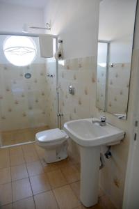 a bathroom with a toilet and a sink and a mirror at Pousada Segredo in São João del Rei +38 photos