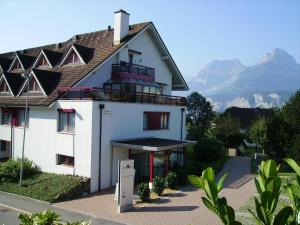 a large white building with mountains in the background at Apart Holidays in Morschach
