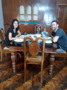 a man and a woman sitting at a table at Kumarakom Wood Castle Serviced Appartments in Kumarakom