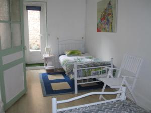 a bedroom with a bed and a chair and a window at Gite de la Madeleine 80 m2 in Tournus