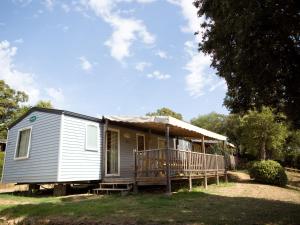 a tiny house with a porch and a deck at Camping La Vetta in Porto-Vecchio