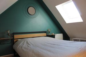 a bedroom with a bed with a mirror and a window at Chalet calme et cosy entre terre et mer in Berck-sur-Mer