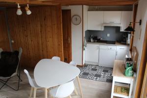 a kitchen with a table and a white table and chairs at Chalet calme et cosy entre terre et mer in Berck-sur-Mer