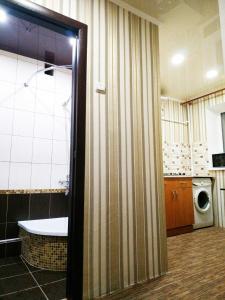 Shostka的住宿－центр вулиця Миру，带浴缸和洗衣机的浴室。