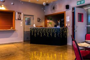 a bar in a restaurant with a counter and chairs at Masonic Hotel in Palmerston North +30 photos