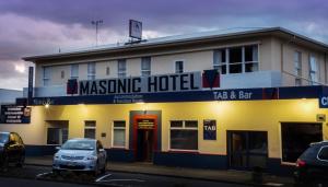 a masino hotel with a car parked in front of it at Masonic Hotel in Palmerston North