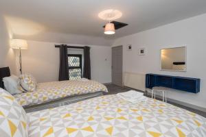 a bedroom with two beds and a ceiling fan at Minfordd in Llanfairpwllgwyngyll