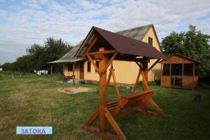 a house with a roof on top of a wooden structure at Затока in Svityazʼ