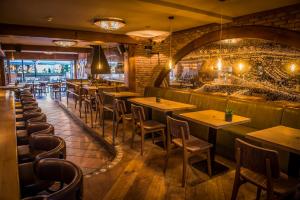 a restaurant with wooden tables and chairs and a brick wall at Boutique Hotel De Smulpot in Den Burg