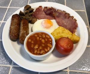 a plate of breakfast food with sausage beans and eggs at Cameron House in Landford