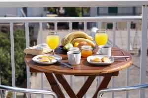 un tavolo in legno con prodotti per la colazione e bevande su un balcone di Syriti Studios a Skala di Cefalonia