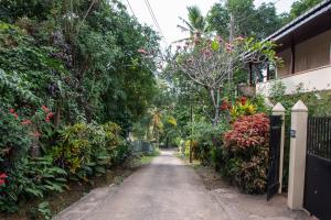 a garden path with flowers and a fence at Tenora Apartment in Kandy