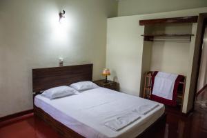 ein Schlafzimmer mit einem großen Bett mit weißer Bettwäsche in der Unterkunft Tenora Apartment in Kandy