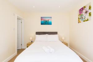 a bedroom with a white bed with two lamps at Leamington Spa Town House 2-Bed, 2 Bath in Leamington Spa