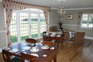 a dining room with a table and chairs and windows at Chadwell Hill Farm in Longwick