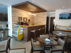 un restaurante con mesas y sillas y un bar en Gaia Apart Hotel, en Tarija