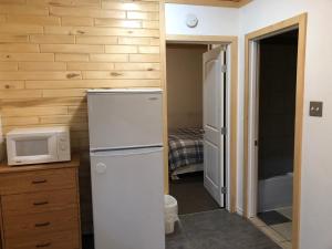 Una pequeña cocina con nevera y microondas. en Alpine motel, en Rocky Mountain House