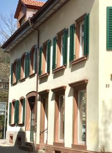 ein Gebäude mit grünen Fensterläden an der Seite in der Unterkunft Appartment Chupferschmied - Wohlfühlen im Altstadtambiente in Schopfheim