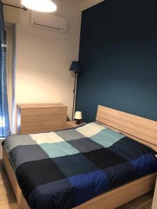 a bedroom with a bed with a black and blue blanket at Trinità City Centre in Catania