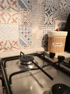 a gas stove top in a kitchen with tiles at Trinità City Centre in Catania