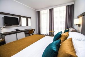a hotel room with a large bed and a desk at Best Western PLUS Premium Inn in Sunny Beach