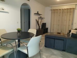 a living room with a table and chairs and a couch at Apartamento playa - Puerto Banus in Marbella