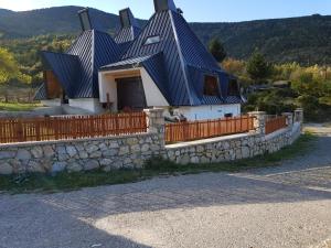 a house with a blue roof and a stone wall at Vila Piramida in Bitola