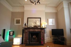 a living room with a fireplace with a mirror and a tv at SW4 Apartment Clapham Common in London