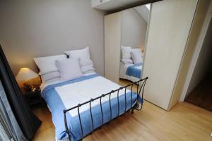 a small bedroom with a bed and a mirror at SW4 Apartment Clapham Common in London