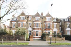 une grande maison en briques avec une clôture devant elle dans l'établissement SW4 Apartment Clapham Common, à Londres