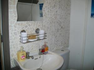 un bagno con lavandino, specchio e WC di Stone Cottage a Ménéac