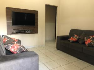 a living room with two couches and a flat screen tv at Casa temporada centro capitolio MG in Capitólio