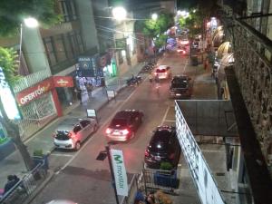 un grupo de coches conduciendo por una calle de la ciudad por la noche en Hostal, home sweet home, en Salto