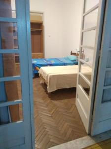 Habitación con 2 camas y puerta abierta en Hostal, home sweet home, en Salto