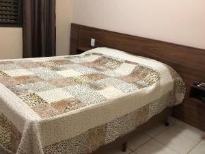 a bed with a quilt on it in a room at Casa temporada centro capitolio MG in Capitólio