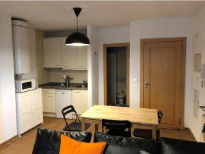 salon z drewnianym stołem i kuchnią w obiekcie Loft con WiFi y Parking en el corazón de Sierranevada w mieście Sierra Nevada