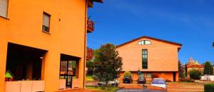 an orange building with a car parked in front of it at Appartamento Gioia (piano terra) in Assisi