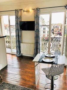 a living room with a table and a balcony at Le cœur de Troyes - Appartement & Studio in Troyes