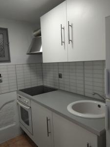 a white kitchen with a sink and a counter top at R&G SALOU CENTER in Salou