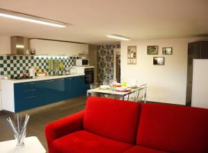 Una sala de estar con un sofá rojo y una cocina. en La Caletta Casa Vacanze, PRIVATE POOL, en Terrasini