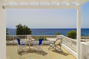 a patio with a table and chairs and the ocean at Dolphins Apartments in Kamari