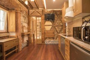 a kitchen with wooden floors and a tv on the wall at Romantic Medieval Apartment in Lisbon